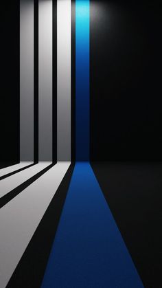 an empty room with blue and white stripes on the floor in front of a black wall