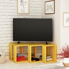 a flat screen tv sitting on top of a wooden shelf