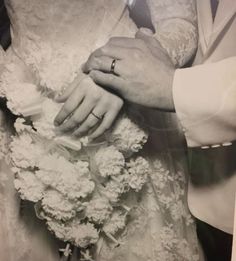 an old black and white photo of a bride and groom holding each other's hands