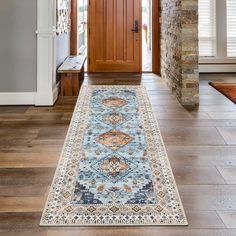 a blue rug is on the floor in front of a wooden door and brick pillars