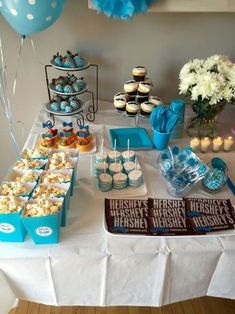 a table topped with lots of desserts and cupcakes