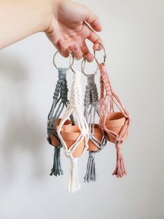 a hand holding four different colored tassels in it's palm tree holder