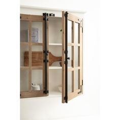 an open wooden cabinet with glass doors on the side and shelves below it, in front of a white wall