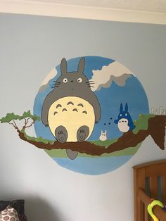 a child's bedroom with a totoro mural on the wall