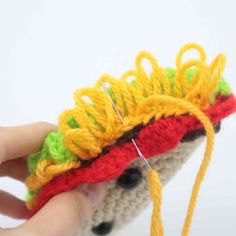 a hand holding a crocheted object with yarn