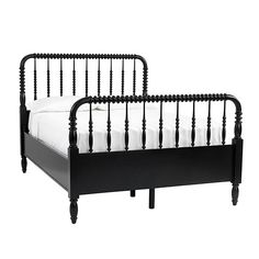 a black metal bed frame with white sheets