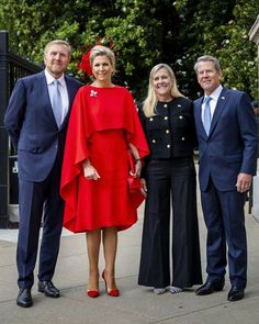 three people standing next to each other on a sidewalk