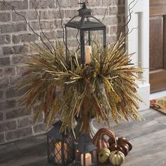 a lantern is sitting on the floor next to some pumpkins and other autumn decorations