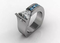 a ring with a princess cut diamond and blue topaz stones on the side, set in 18k white gold