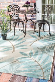 an outdoor area rug with chairs and table