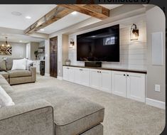 a living room filled with furniture and a large flat screen tv mounted on the wall