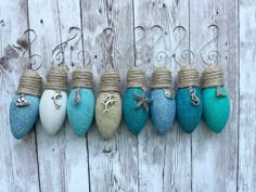 five different colored shoes are hanging on a wooden wall, with rope wrapped around them