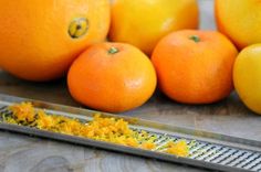 several oranges sitting on top of a grate next to some other citrus fruits