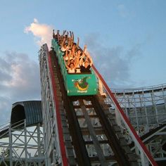 people are riding on the roller coaster at an amusement park