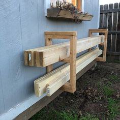 two wooden benches sitting on the side of a building