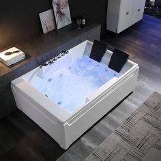 a bath tub sitting on top of a floor next to a table with two candles