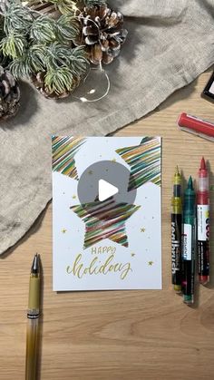 a christmas card sitting on top of a table next to crayons and markers