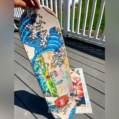 a person holding a skateboard on top of a wooden deck next to a white fence