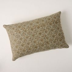 a brown and green pillow sitting on top of a white wall