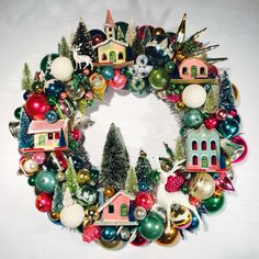 a christmas wreath with ornaments and houses on it