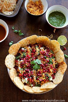 a bowl filled with food sitting on top of a table next to bowls of sauce