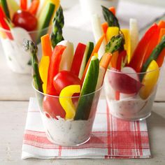 small glass cups filled with vegetables on top of a table