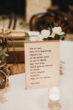 a table topped with two vases filled with flowers and candles sitting next to each other