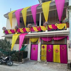 a building with yellow and pink curtains hanging from it's windows