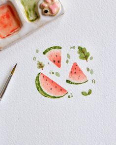 watermelon slices and leaves drawn on white paper next to a paintbrush, stamp pad and small animal figurine