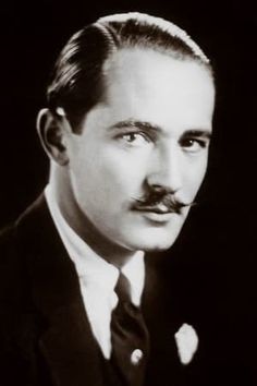 a man in a suit and tie with a moustache