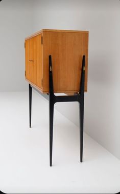 an old wooden cabinet with two black legs