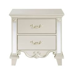 a white nightstand with two drawers on each side and one drawer open to reveal an ornate design