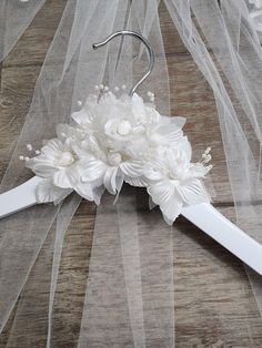 the bridal hair comb is adorned with white flowers and pearls, along with veils