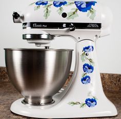 a white mixer with blue flowers painted on it