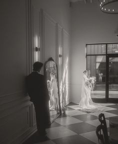 a bride and groom standing in front of a mirror at the end of their wedding day