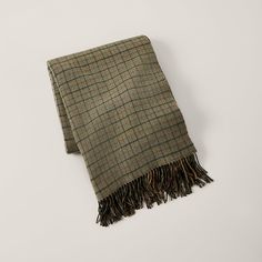 a brown and black plaid blanket on a white background with fringes around the edges