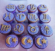 purple cupcakes decorated with zodiac symbols and stars