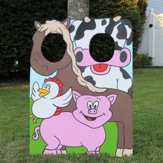 a painted cow and pig themed cornhole toss game