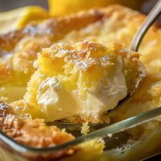 a close up of a spoon in a dish of food with lemons behind it