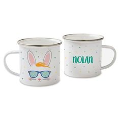 two white enamel mugs with bunny ears and glasses on them, one has the word noan written in green