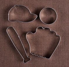 three cookie cutters and two cookies on a brown cloth