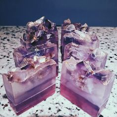 three purple ice cubes sitting on top of a marble counter next to each other