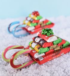 two small christmas trees made out of candy bars and candy canes in the snow