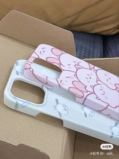 a pink and white phone case sitting on top of a cardboard box