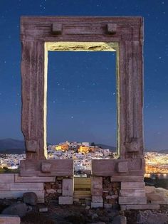 an old stone structure with a view of the city in the background at night time