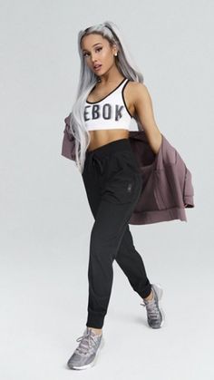 a woman with long grey hair is posing for a photo in her sports bra top and black sweatpants