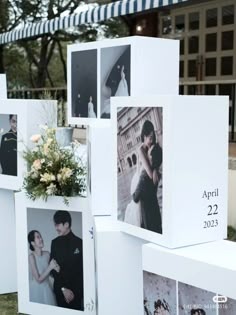 several white boxes with pictures on them and flowers in the middle one box is holding a bouquet