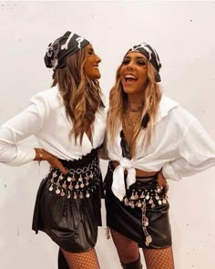 two women dressed in black and white posing for the camera with their hands on their hipss