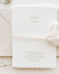 the wedding stationery is laid out on top of each other