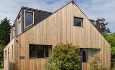 a house made out of wood with windows on the roof and two levels that are connected to each other